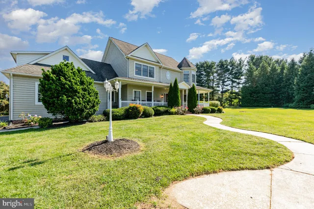 a front view of a house with a yard and potted plants