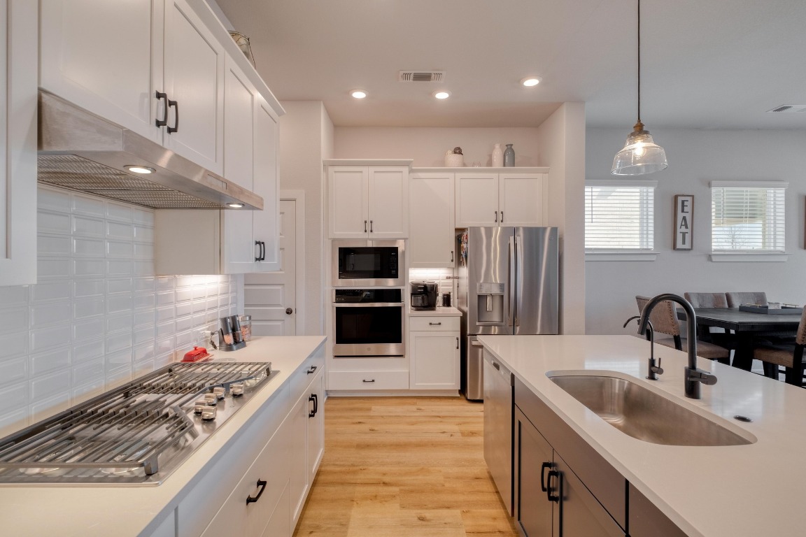 1113 Dog Iron Street Georgetown, TX 78633 - Photo 13 of 33 a large kitchen with stainless steel appliances granite countertop a sink stove and refrigerator
