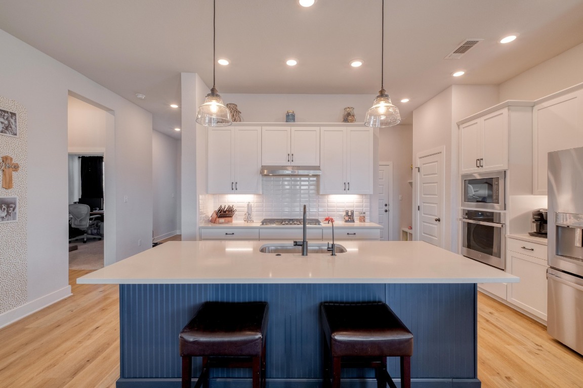 1113 Dog Iron Street Georgetown, TX 78633 - Photo 10 of 33 a kitchen with stainless steel appliances a dining table chairs sink and cabinets