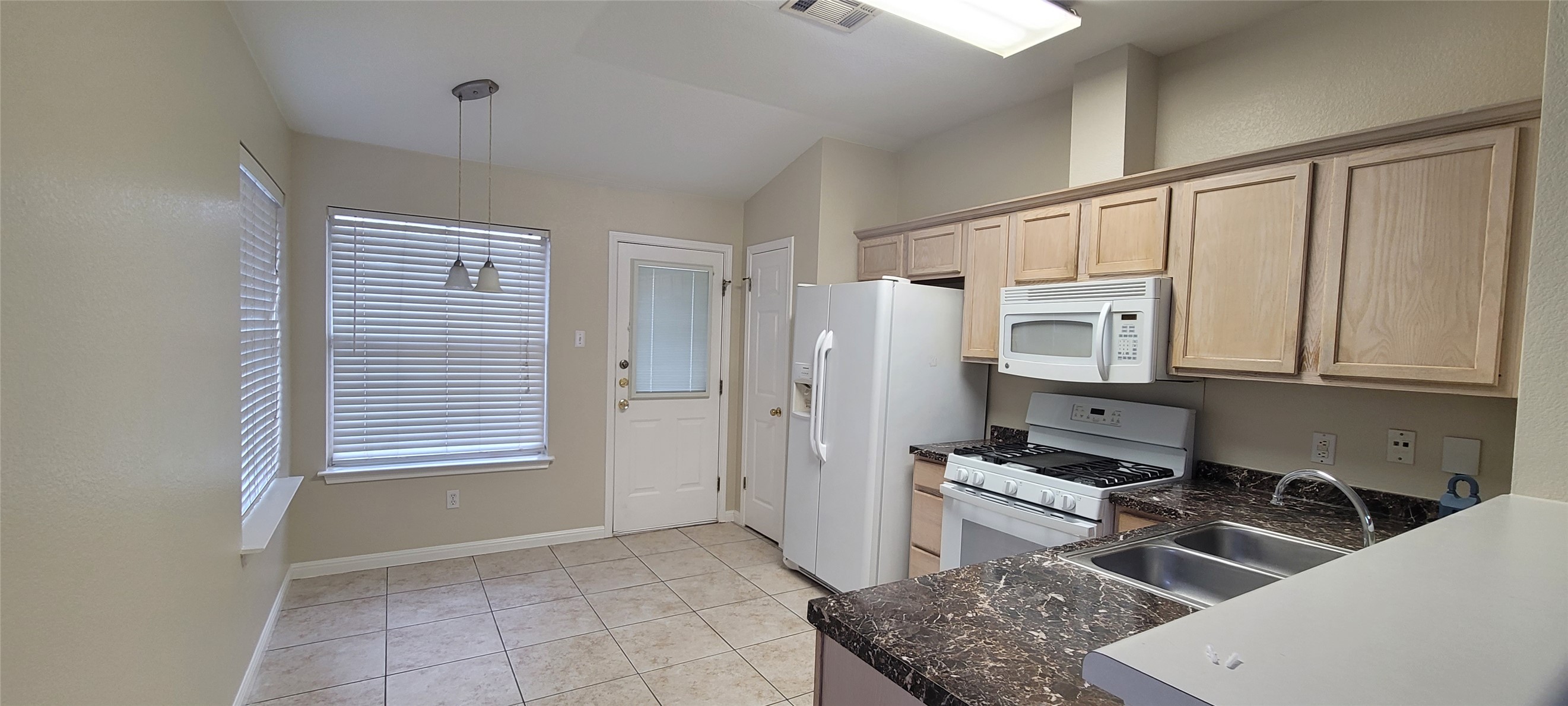 14612 Rumfeldt Street Austin, TX 78725 - Photo 4 of 9 a kitchen with stainless steel appliances granite countertop a refrigerator and a stove top oven
