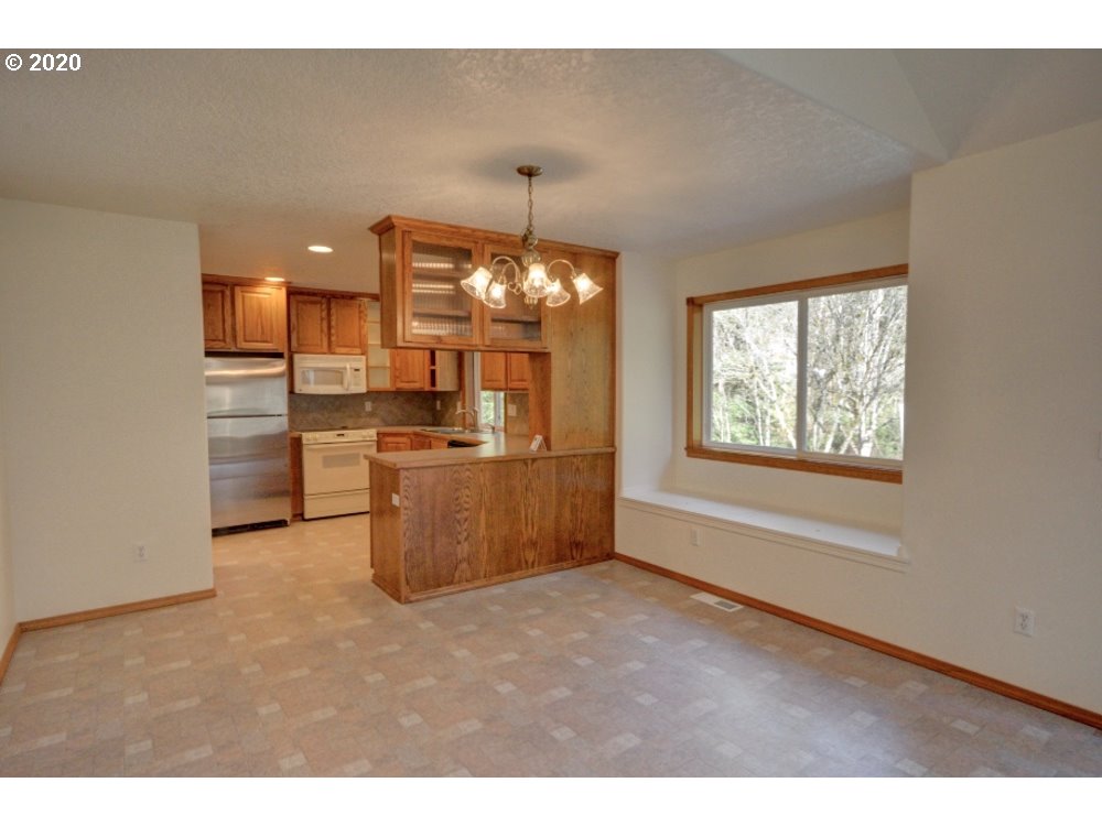 67051 East Barlow Trail Road Rhododendron, OR 97049 - Photo 8 of 32 a kitchen with refrigerator and cabinets