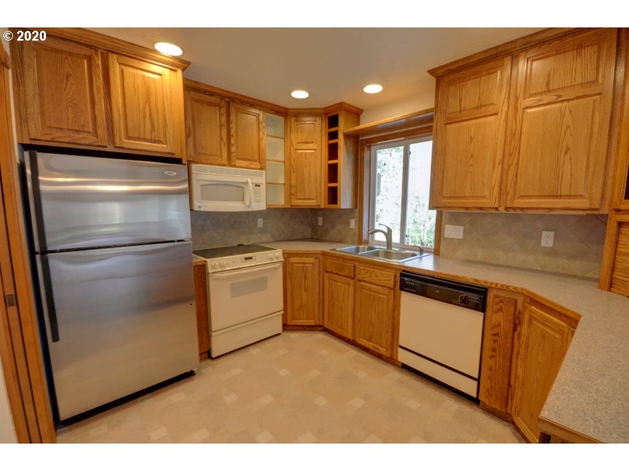 67051 East Barlow Trail Road Rhododendron, OR 97049 - Photo 10 of 32 a kitchen with a refrigerator sink and cabinets