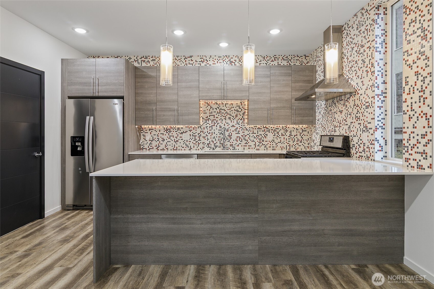 9221 Linden Avenue North, Unit A Seattle, WA 98103 - Photo 7 of 29 a view of a kitchen with kitchen island a sink stainless steel appliances and cabinets