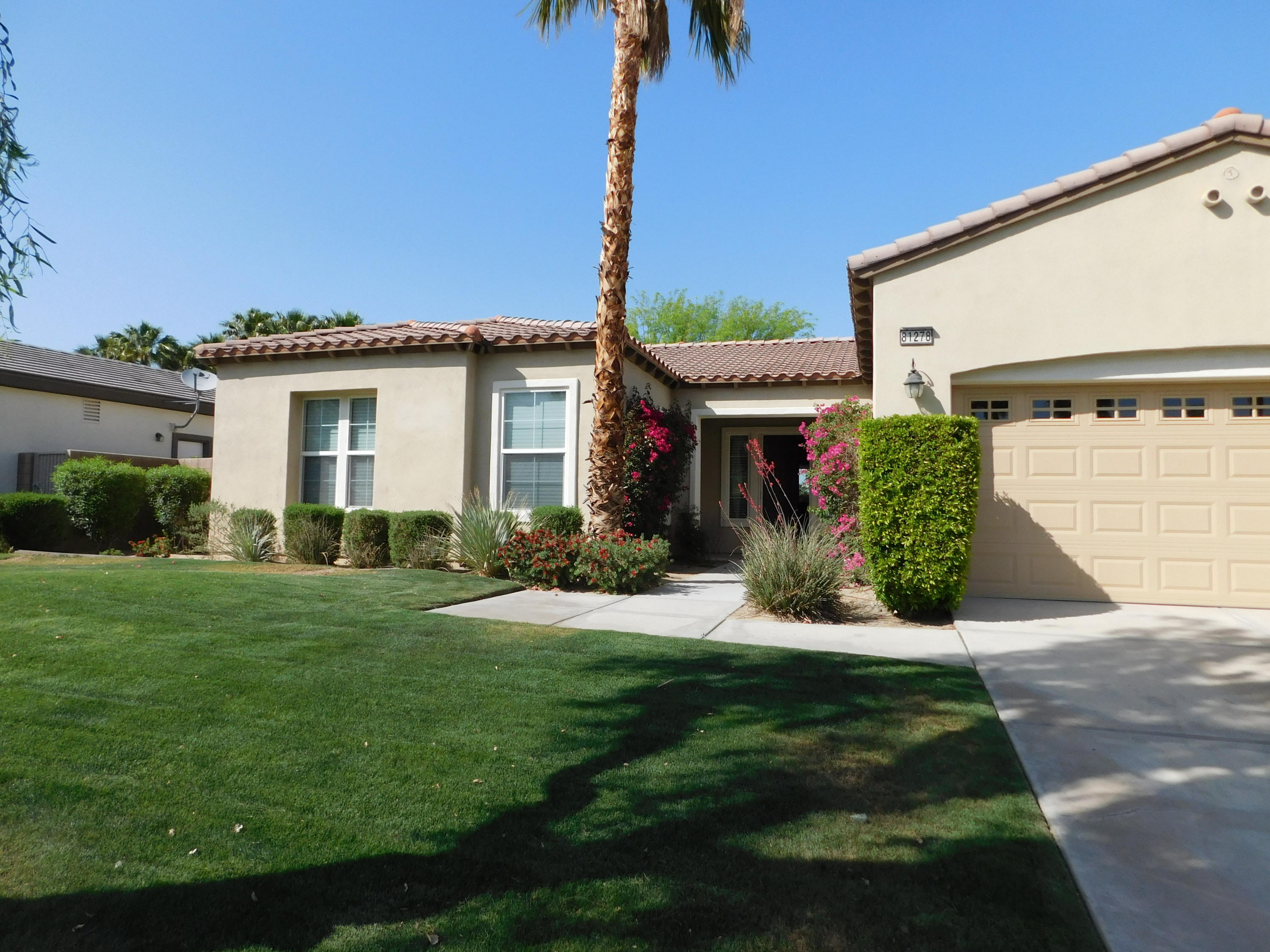 a front view of a house with a yard and potted plants