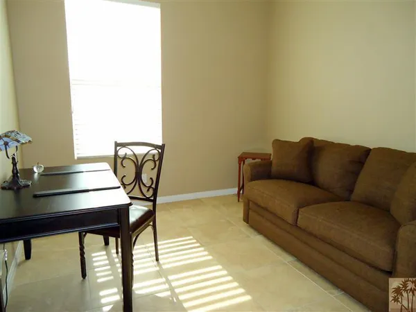 a living room with a couch and a potted plant next to a window