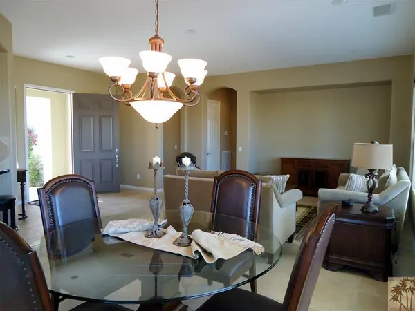 a dining room with furniture a chandelier and wooden floor
