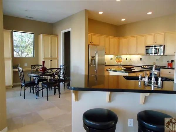 a kitchen with kitchen island a stove and a dining table