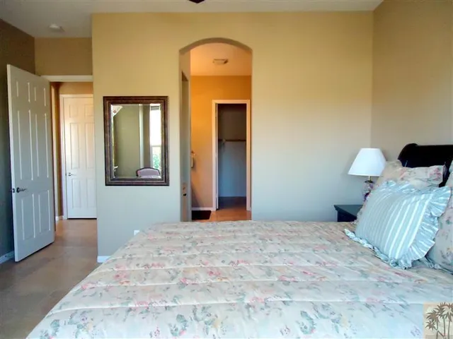 a bedroom with a bed and mirror