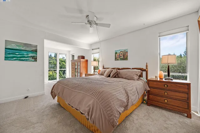 a large bed sitting in a bedroom next to a window