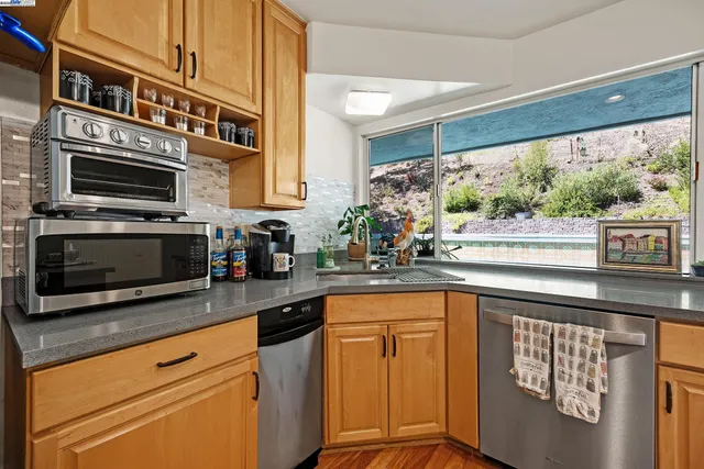 a kitchen with stainless steel appliances granite countertop a stove microwave and cabinets