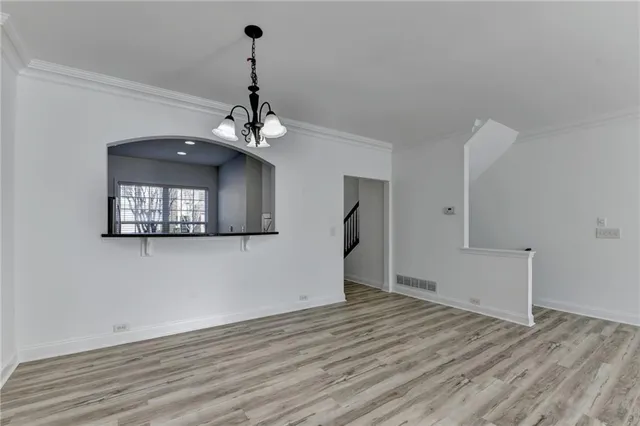 a view of empty room with wooden floor and ceiling fan