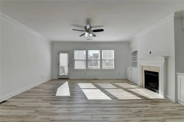 a view of an empty room with a fireplace and a window