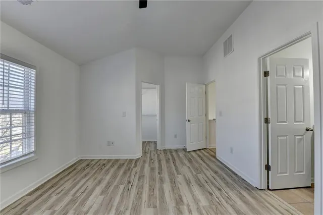 an empty room with closet and windows