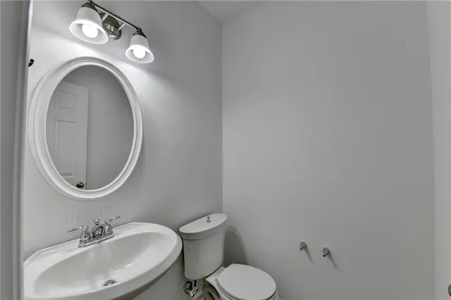 a bathroom with a toilet a sink and a mirror