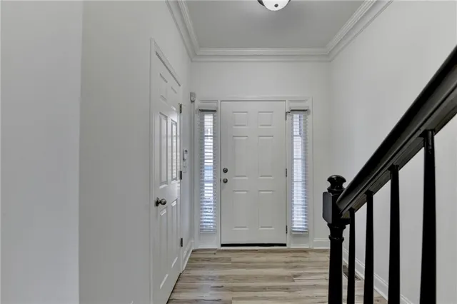 a view of a hallway with wooden floor and staircase