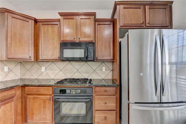 a kitchen with stainless steel appliances wooden cabinets and a refrigerator