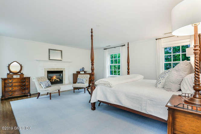 16 Normandy Lane Riverside, CT 06878 - Photo 26 of 43 a bedroom with a bed chair and fireplace