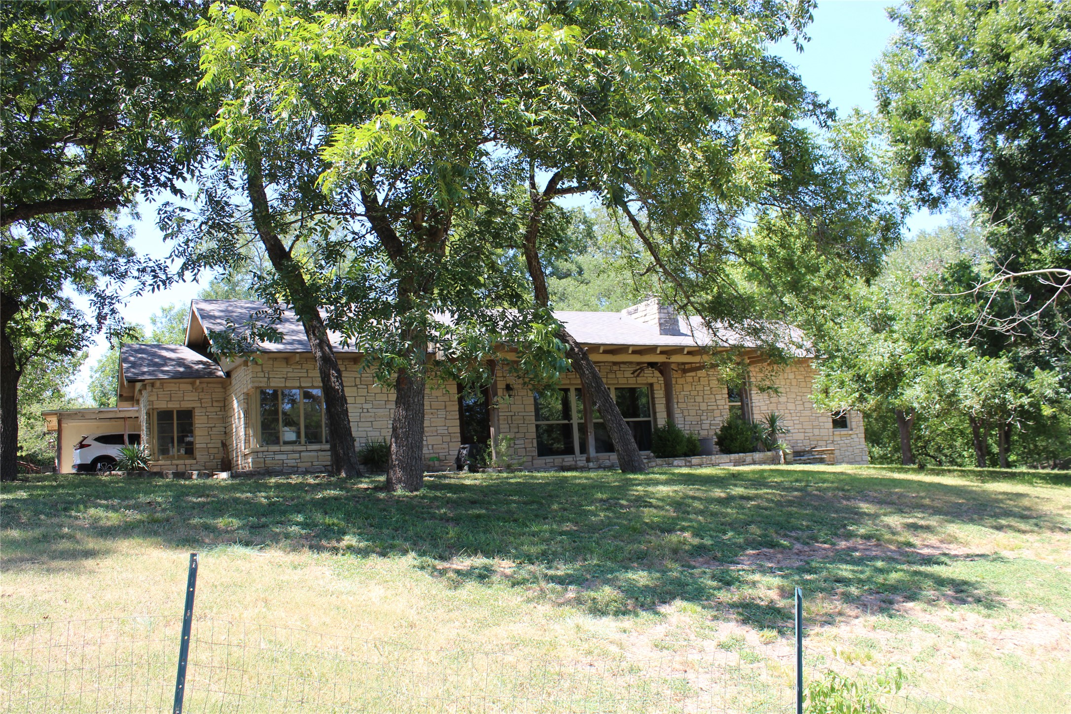 View of front of house featuring a front lawn and stone siding