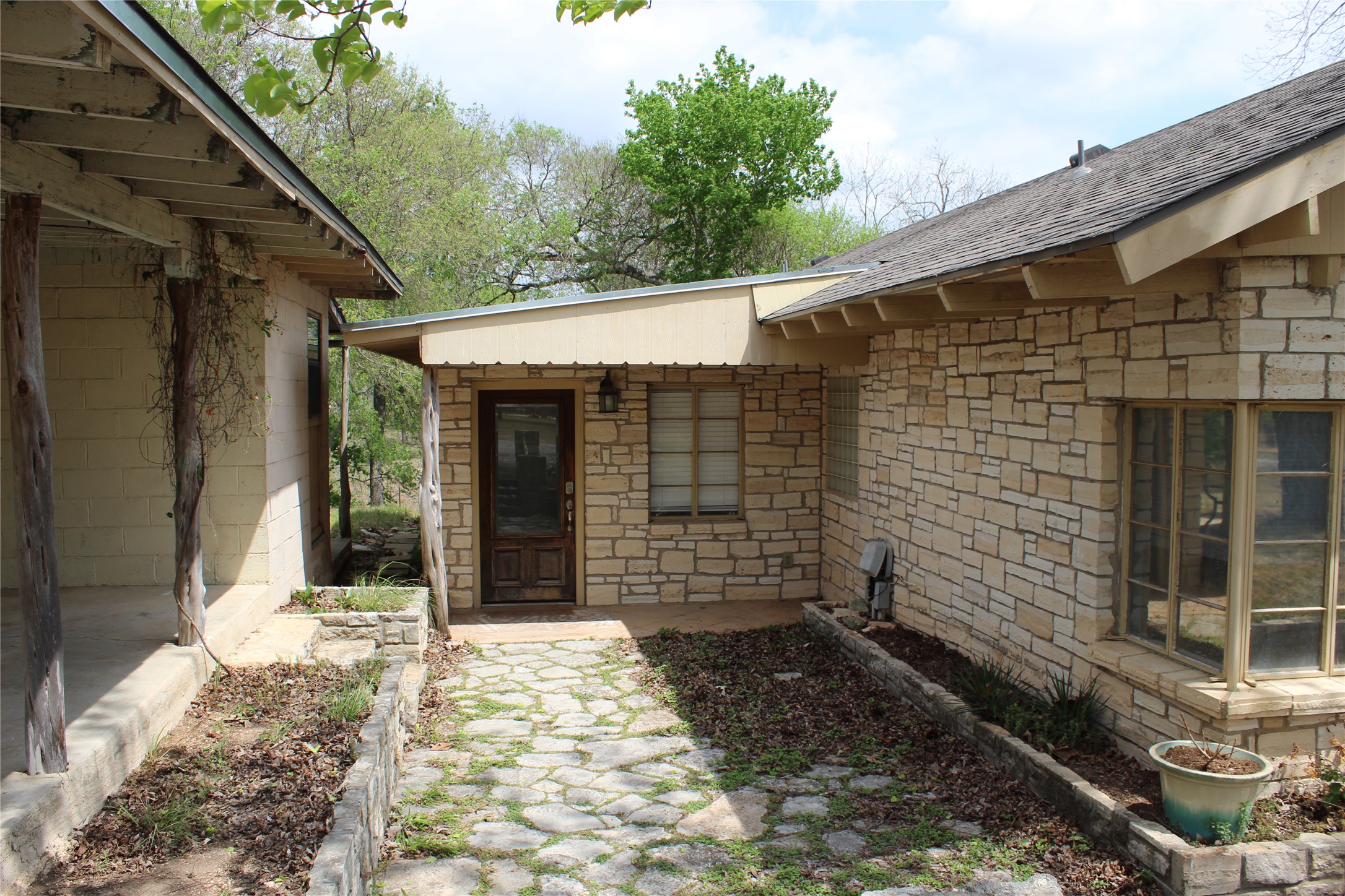 908 River Road Wimberley, TX 78676 - Photo 16 of 16 Property entrance featuring stone siding and roof with shingles