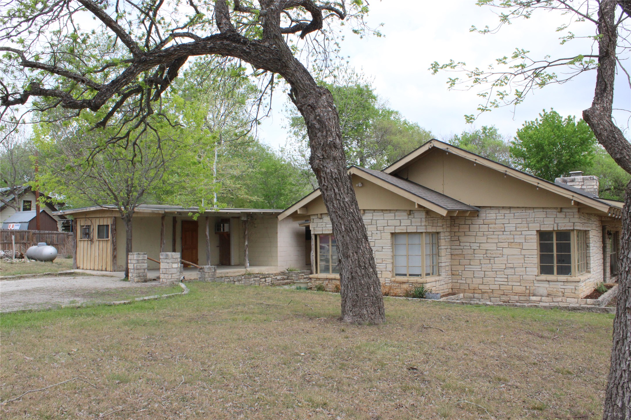 908 River Road Wimberley, TX 78676 - Photo 3 of 16 Single story home with stone siding, a chimney, and a front yard