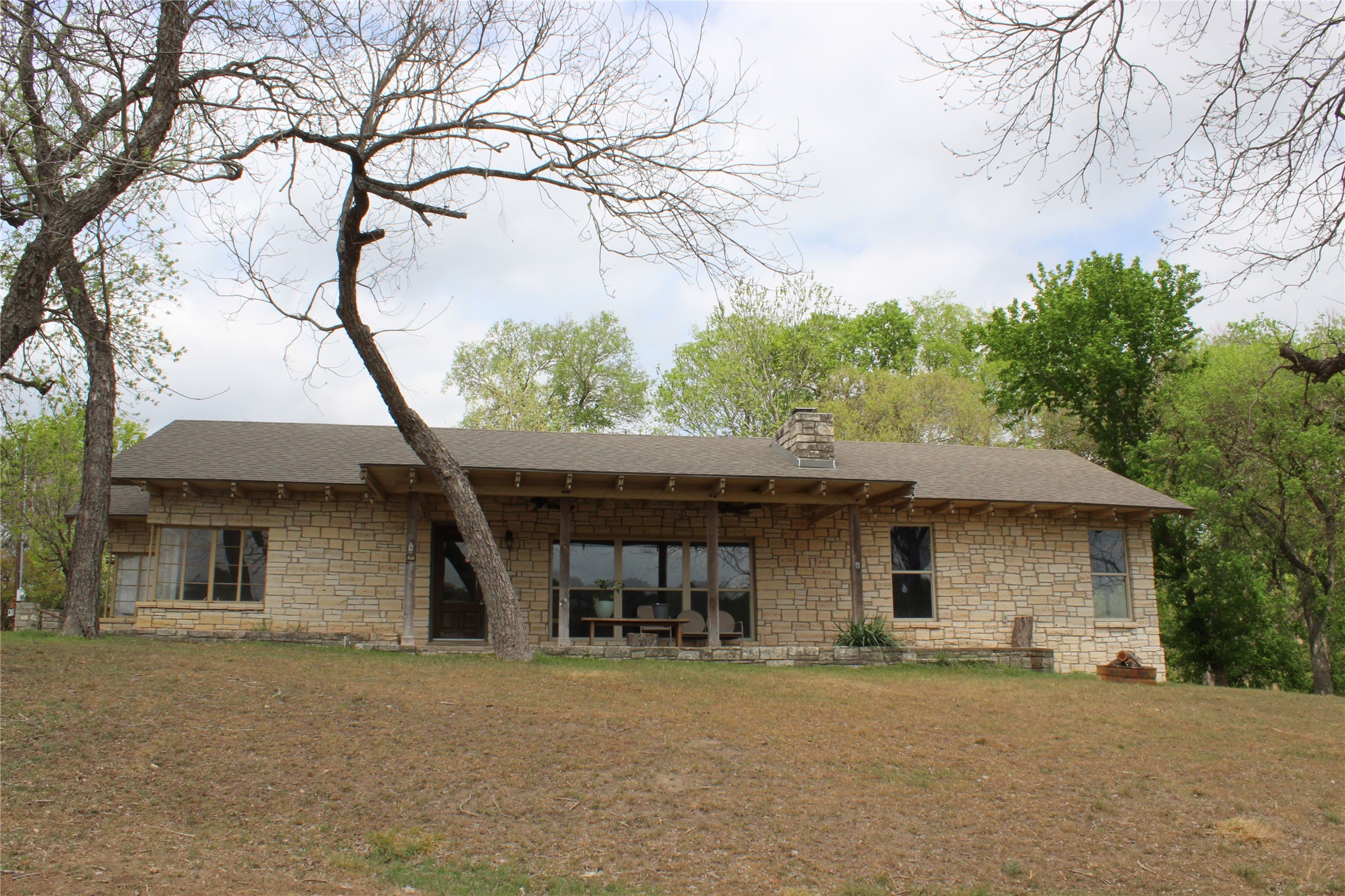 908 River Road Wimberley, TX 78676 - Photo 4 of 16 Back of property with stone siding, a lawn, and a chimney