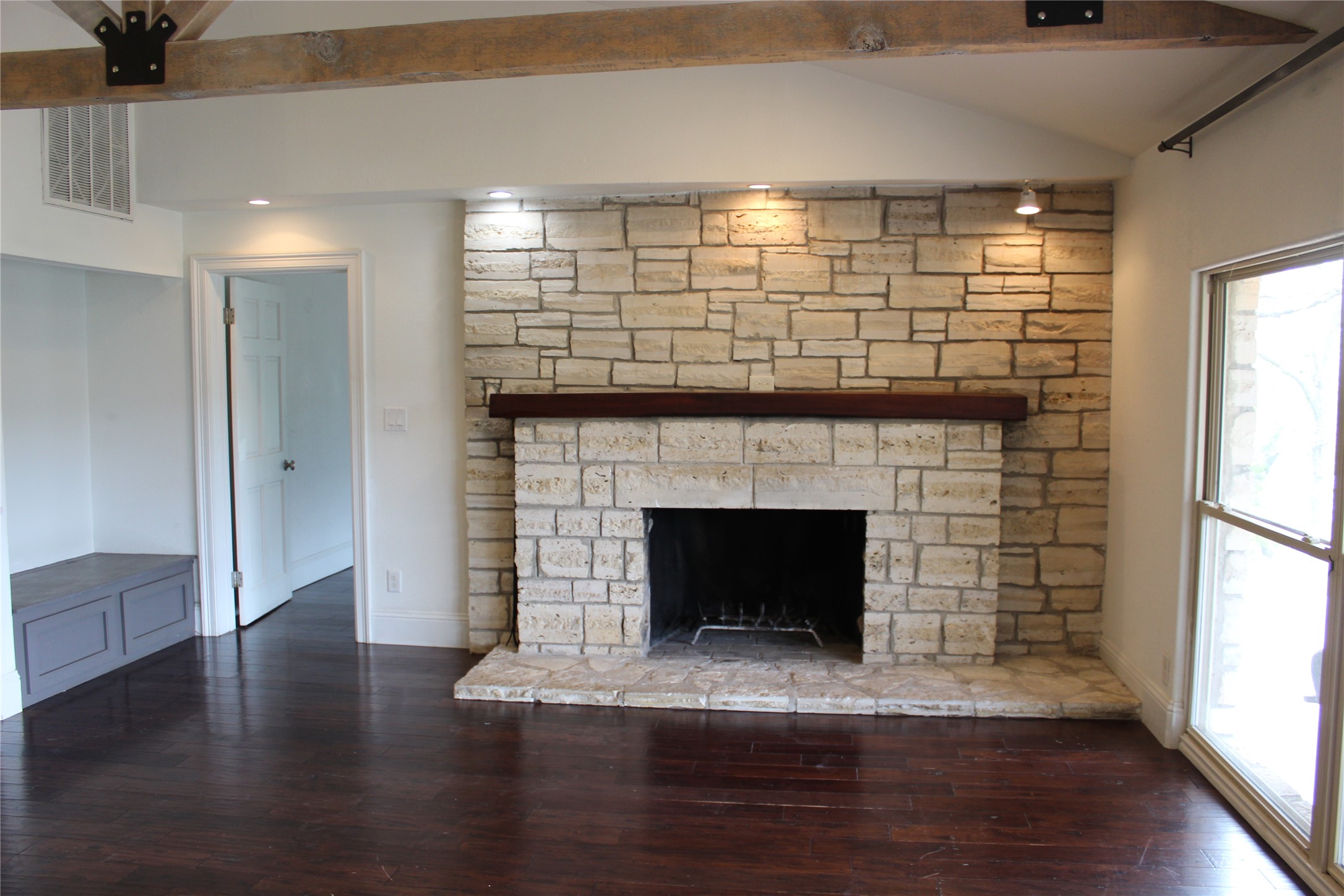 908 River Road Wimberley, TX 78676 - Photo 8 of 16 Detailed view of wood finished floors, beam ceiling, and a fireplace
