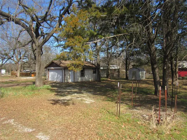 a view of a yard with wooden fence and a large tree