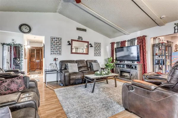 a living room with furniture a flat screen tv and a fireplace