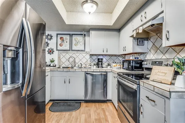 a kitchen with stainless steel appliances granite countertop a stove a sink and a refrigerator