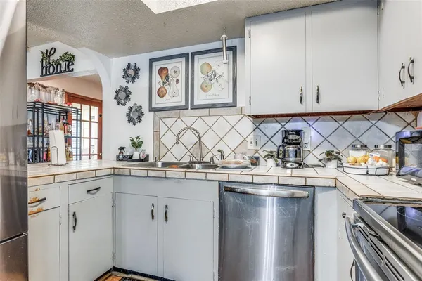 a kitchen with stainless steel appliances granite countertop a sink and a stove