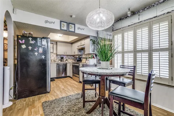 a kitchen with stainless steel appliances granite countertop a stove a refrigerator and a dining table