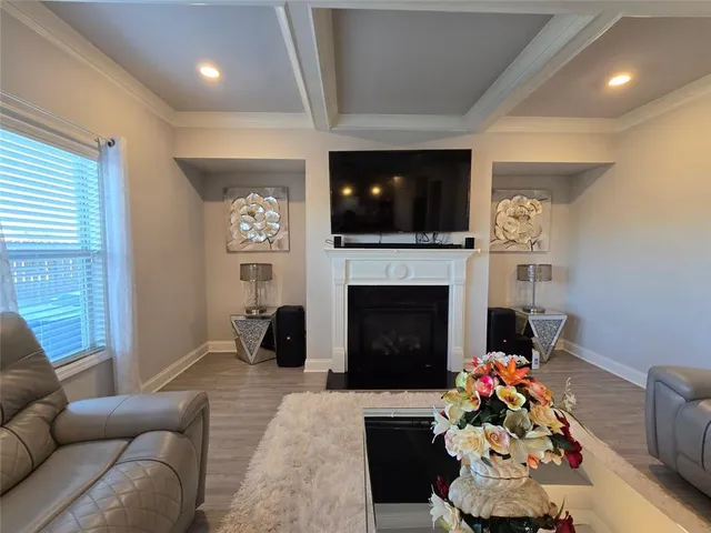a living room with furniture a flat screen tv and a fireplace