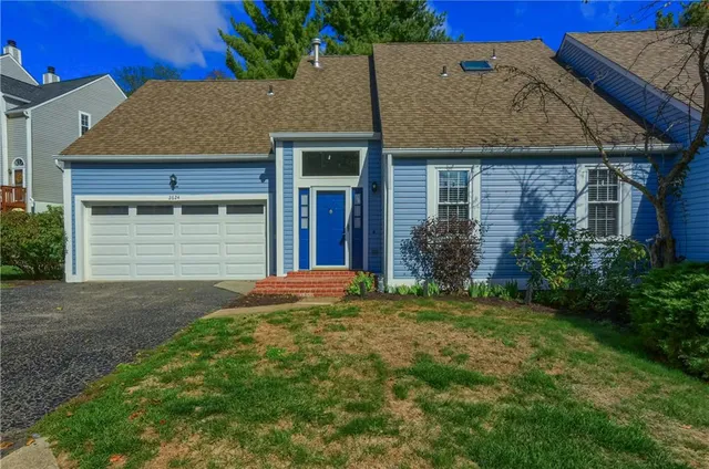 a front view of a house with a garden and garage