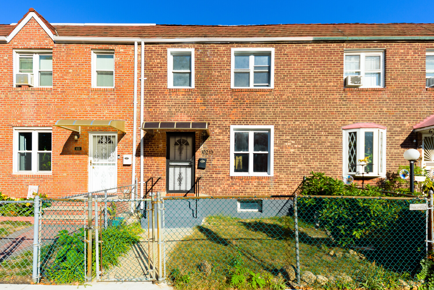102 183rd Place Queens, NY 11423 - Photo 12 of 13 a front view of a house with a yard