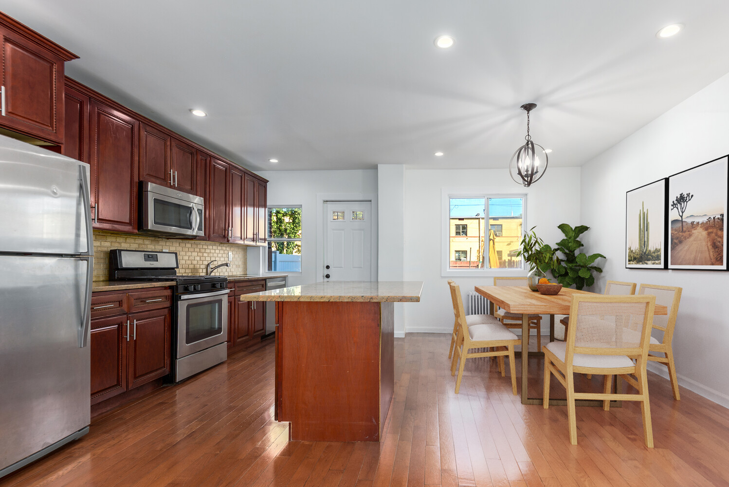 102 183rd Place Queens, NY 11423 - Photo 3 of 13 a kitchen with stainless steel appliances granite countertop wooden floor a dining table and chairs