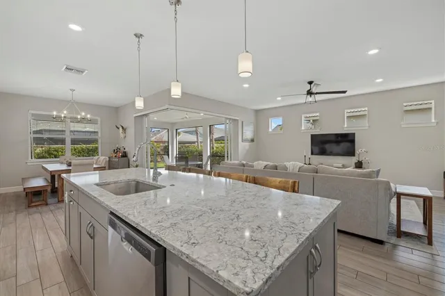 a kitchen with granite countertop a sink a counter top space and stainless steel appliances