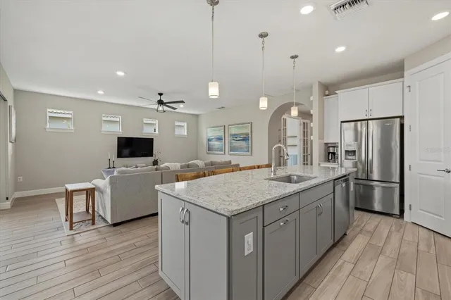 a kitchen with a center island wooden floor and stainless steel appliances