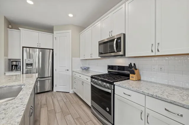 a kitchen with granite countertop a refrigerator stove and microwave