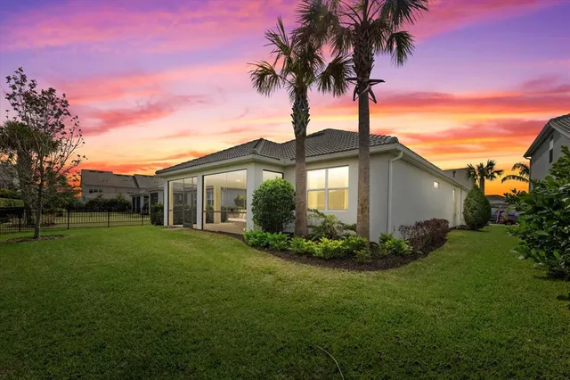 a view of a big yard with flower plants and large tree