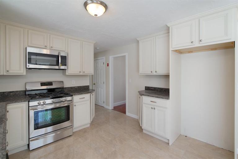 21 Mayflower Road Mashpee, MA 02649 - Photo 8 of 22 a kitchen with white cabinets and stainless steel appliances