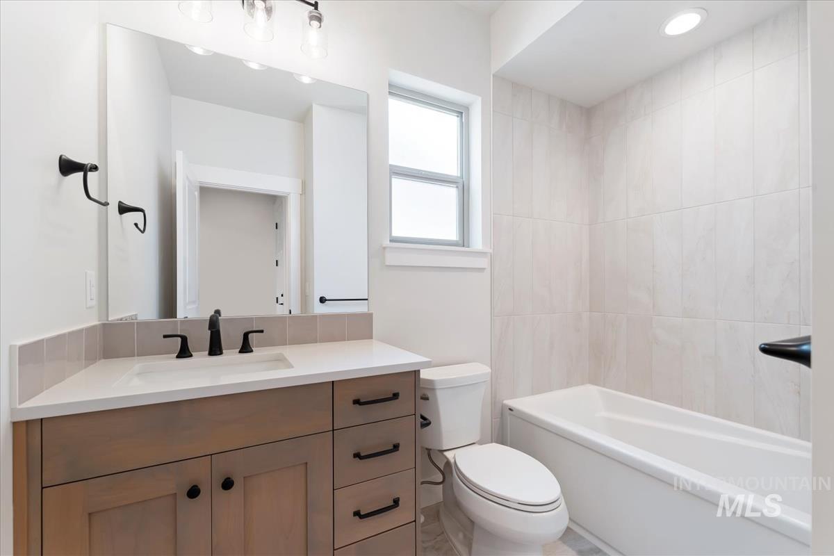 2166 East Rodeo Street Kuna, ID 83634 - Photo 26 of 43 Bathroom featuring a single vanity with wood-finish cabinetry, a white countertop, and a rectangular undermount sink