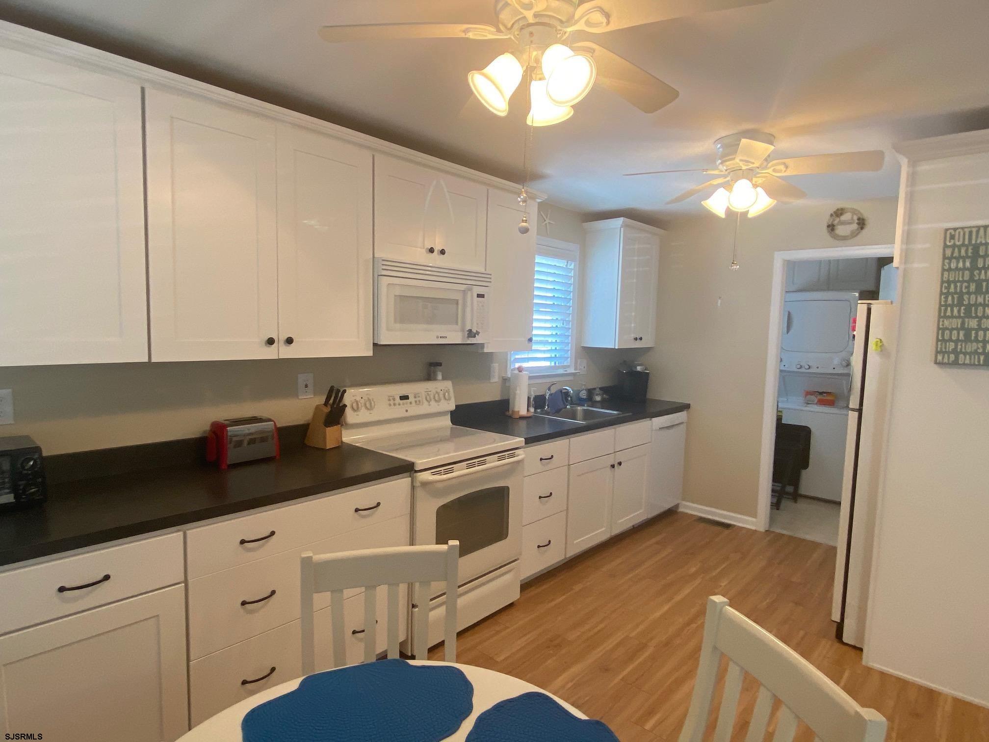 135 North Woodcrest Avenue, Unit MD WEEKEND TO JUNE 30 Longport, NJ 08403 - Photo 5 of 14 a kitchen with cabinets a sink and appliances