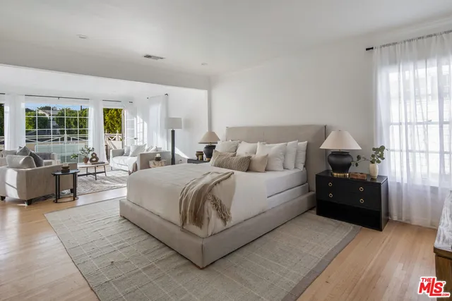 a spacious bedroom with a bed and glass window