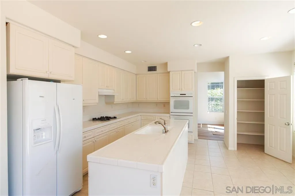 1935 Ivy Road Oceanside, CA 92054 - Photo 11 of 25 a kitchen with a sink a stove a refrigerator and white cabinets