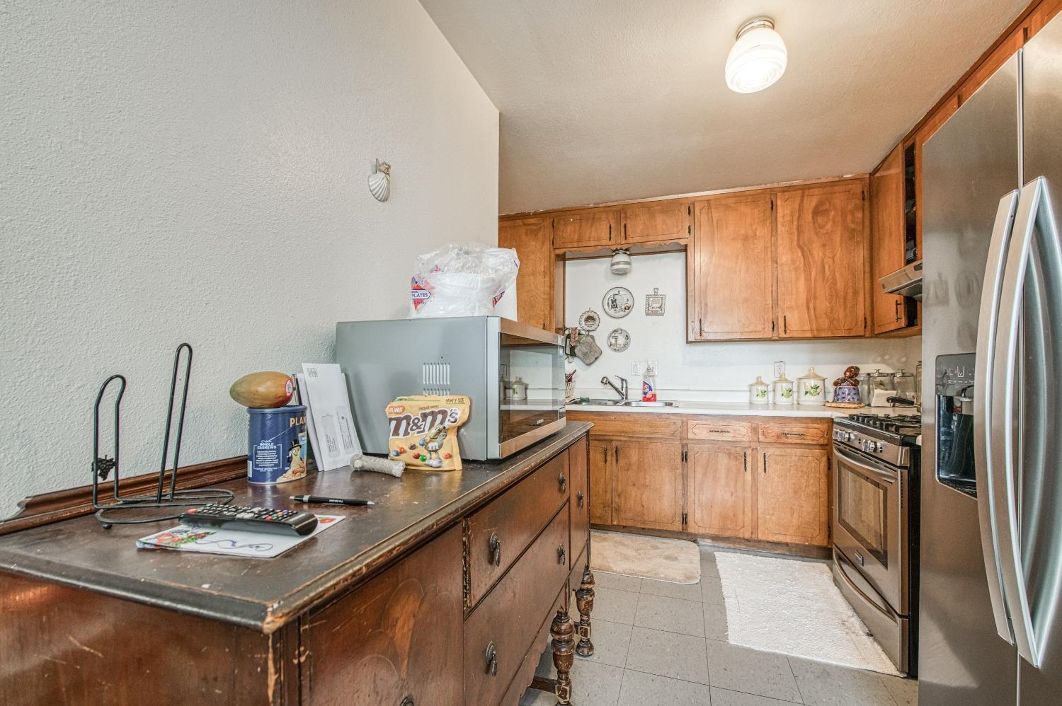 717 Clinton Street Madera, CA 93638 - Photo 15 of 38 a kitchen with stainless steel appliances granite countertop a sink stove and refrigerator