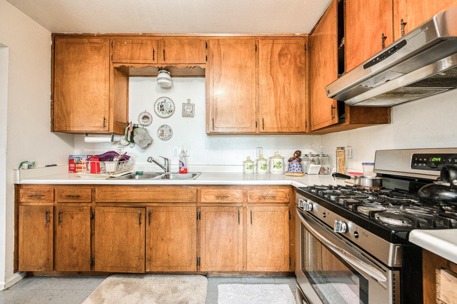 717 Clinton Street Madera, CA 93638 - Photo 16 of 38 a kitchen with a sink stove and cabinets