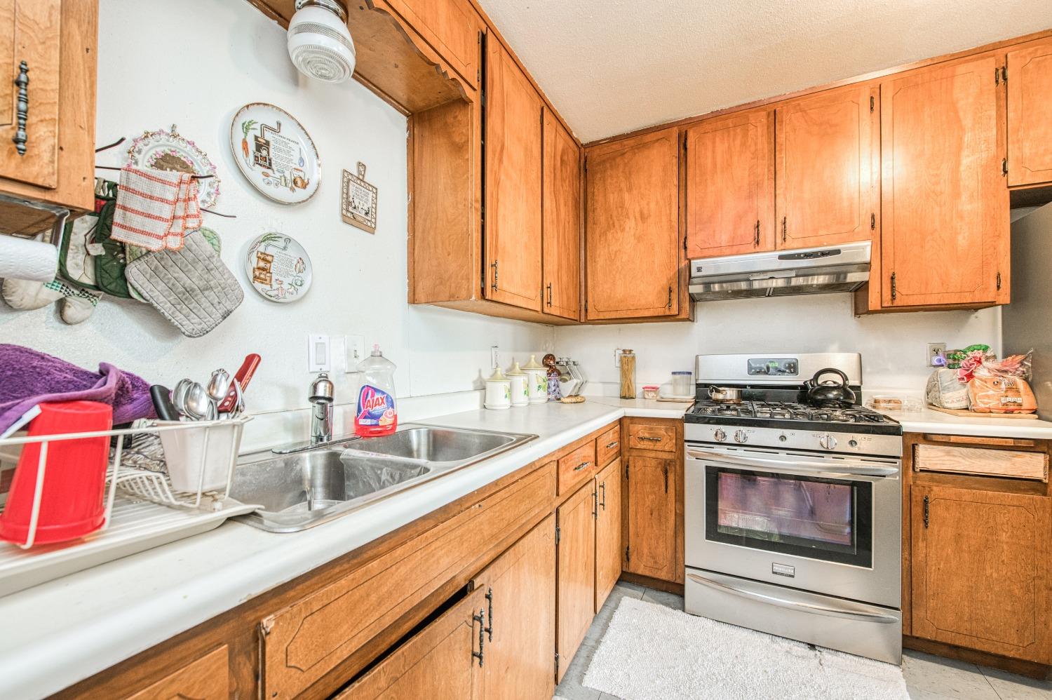 717 Clinton Street Madera, CA 93638 - Photo 17 of 38 a kitchen with stainless steel appliances granite countertop a stove and a sink
