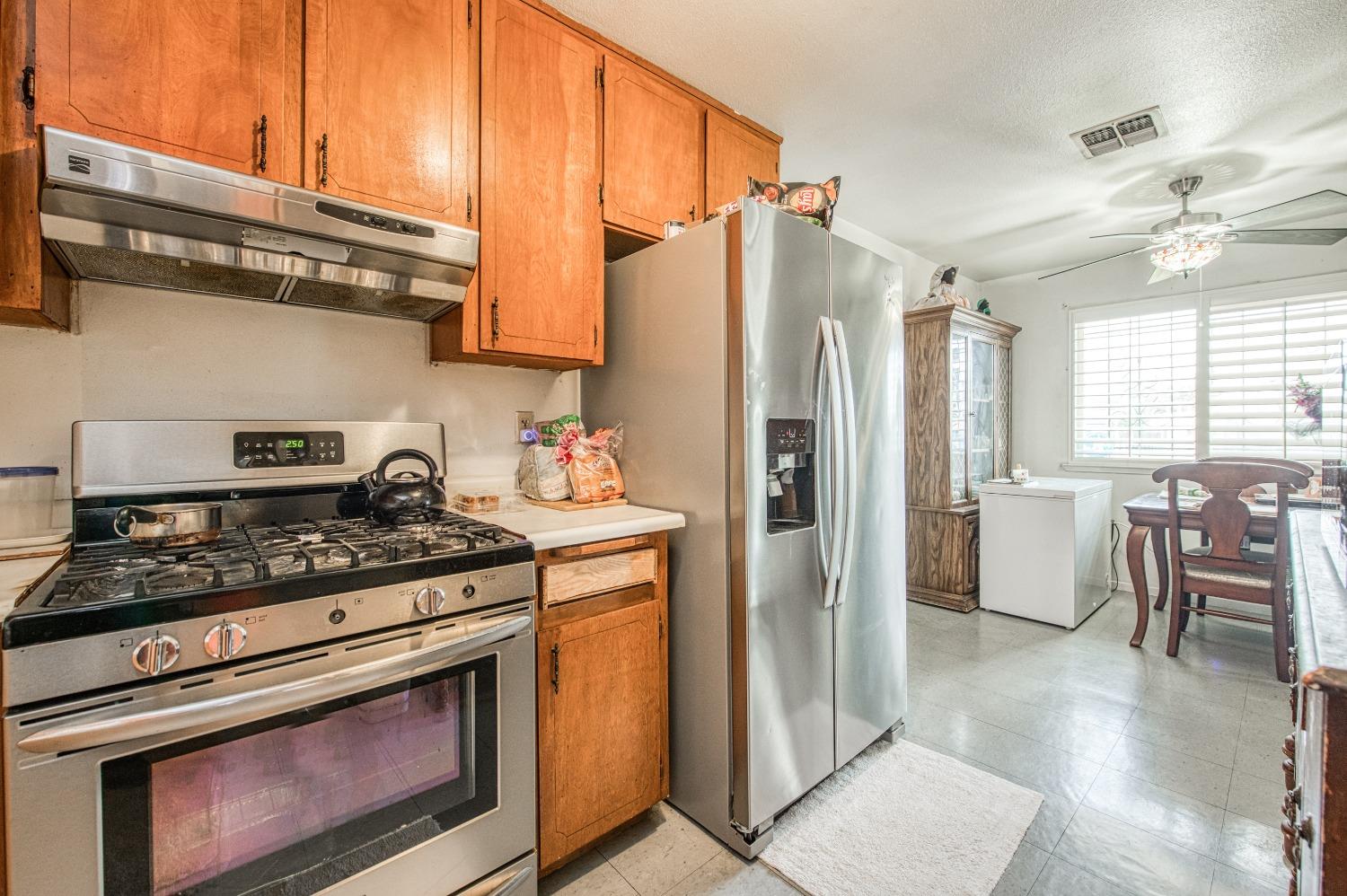 717 Clinton Street Madera, CA 93638 - Photo 18 of 38 a kitchen with stainless steel appliances granite countertop a stove a refrigerator and a cabinets