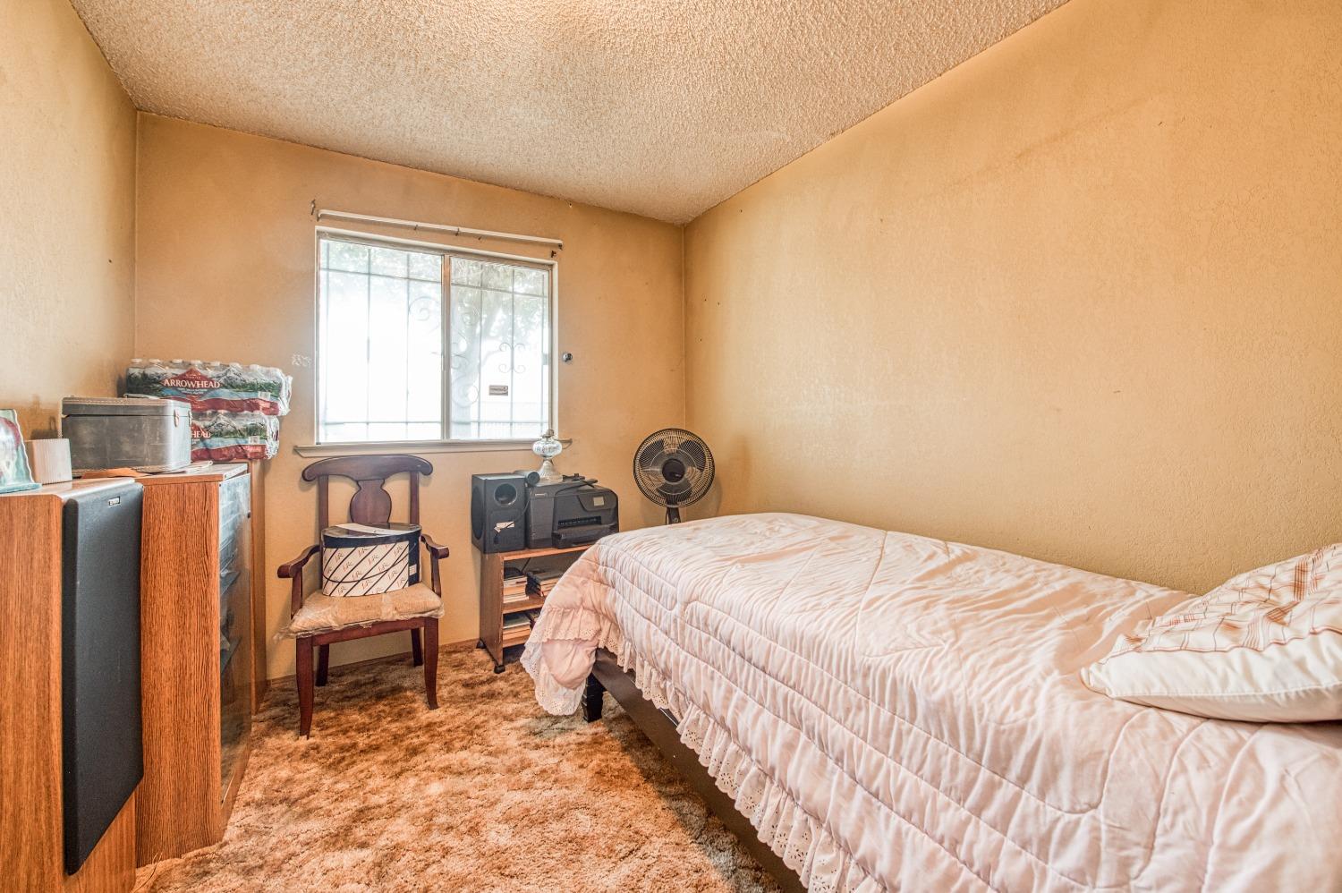 717 Clinton Street Madera, CA 93638 - Photo 21 of 38 a bedroom with a bed and a window