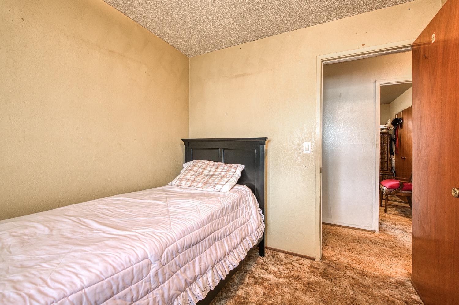 717 Clinton Street Madera, CA 93638 - Photo 22 of 38 a bedroom with a bed and a lamp